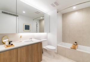 洛杉矶Sky Rise Apartments的浴室配有盥洗盆、卫生间和浴缸。