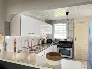 威廉斯塔德Casa Augusto的厨房配有白色橱柜和水槽