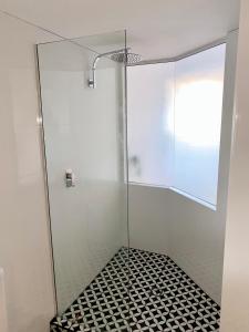 亚历山德拉岬角Resort Queen Studio at Alex Beach Resort的玻璃淋浴间铺有黑白瓷砖地板。