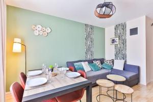 莱萨布勒-多洛讷Appartement cosy, idéalement situé en centre-ville的客厅配有蓝色的沙发和桌子