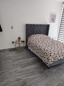 马萨特兰Excelente Depa en Sabalo Country的卧室铺有木地板,配有一张床和一张桌子。