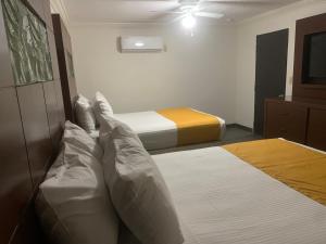 墨西卡利HOTEL DORADO DIAMANTE的一间卧室配有两张床和吊扇