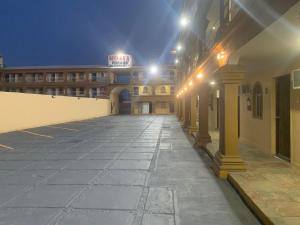 墨西卡利HOTEL DORADO DIAMANTE的夜间大楼前的一个空停车位