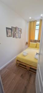 里斯本S.Soares Yellow Beato的一间卧室设有黄色的床,铺有木地板。