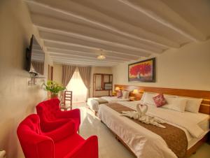 奥兰太坦波Sol Ollantay Exclusive Hotel的酒店客房,设有两张床和两张红色椅子