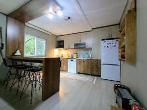 bungalov ve göl kenarina kurulmuş sahil evi.的厨房配有柜台和白色冰箱。