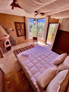 奥伊俄贞Bin Jbal Resort的一张大床,位于带大窗户的房间里