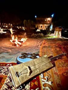 奥伊俄贞Bin Jbal Resort的夜间坐在火坑旁的枪