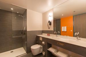 阿姆斯特丹Leonardo Hotel Amsterdam Rembrandtpark的浴室配有卫生间、盥洗盆和淋浴。