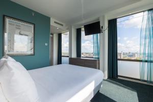 阿姆斯特丹Leonardo Hotel Amsterdam Rembrandtpark的卧室设有白色大床和窗户。