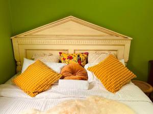 查斯顿Central Located 4BR Home with Rumpus & King Bed in the Heart of Melbourne的一张带黄色枕头和绿色墙壁的床