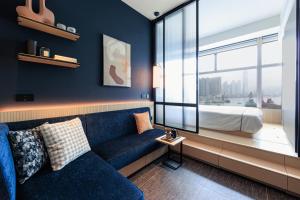 香港TOWNPLACE WEST KOWLOON的客厅配有蓝色的沙发和床。