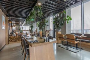 格罗宁根Leonardo Hotel Groningen的餐厅设有酒吧,提供椅子和植物