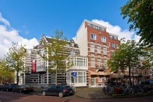 阿姆斯特丹阿姆斯特丹市中心莱昂纳多酒店的一座高大的建筑,前面有汽车停放