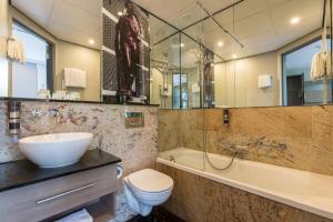 阿姆斯特丹Leonardo Boutique Museumhotel的一间带水槽、浴缸和卫生间的浴室