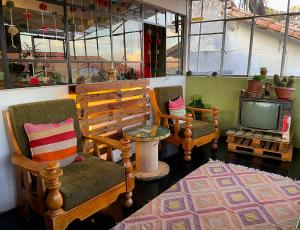 库斯科Eco Home View - Guest House的客厅配有两把椅子和电视