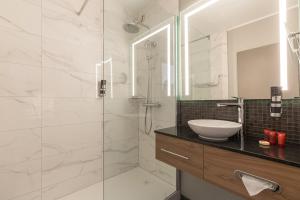 安特卫普莱昂纳多酒店安特卫普酒店的一间带水槽和玻璃淋浴的浴室