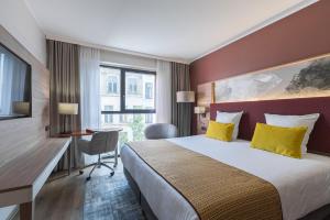 安特卫普莱昂纳多酒店安特卫普酒店的配有一张床、一张书桌和一扇窗户的酒店客房