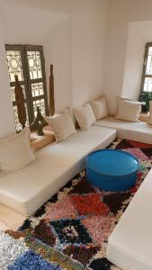 凯拉Kasbah ait Moussa的客厅里设有一张白色沙发,铺着地毯