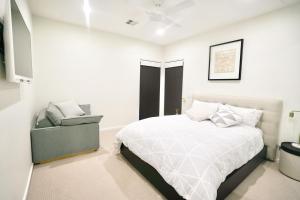 金德拜恩Pinecone Lodge的白色卧室配有床和椅子