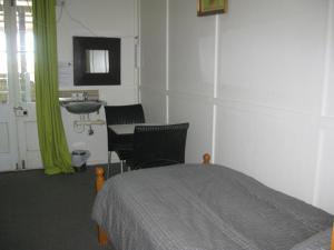 温顿Australian Hotel Winton Budget Hotel Accommodation的一间卧室配有一张床、一个水槽和一张桌子