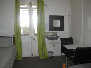 温顿Australian Hotel Winton Budget Hotel Accommodation的一间卧室配有绿色窗帘、水槽和床