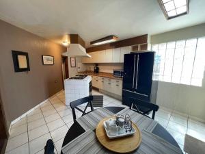 恩塞纳达港Casa Orta Ensenada的厨房配有桌椅和冰箱。