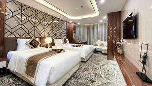 荣市Cửa Đông Luxury Hotel的酒店客房设有两张床和电视。