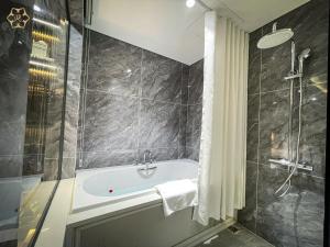 荣市Cửa Đông Luxury Hotel的设有带浴缸和淋浴的浴室。
