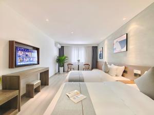 简阳国尚假日酒店(天府国际机场店)的一间酒店客房,设有两张床和电视