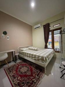 SukarajaSpacious 2BR Home - 14 Min from Sukabumi city Centre by Sakura的一间卧室配有一张带地毯的床和窗户