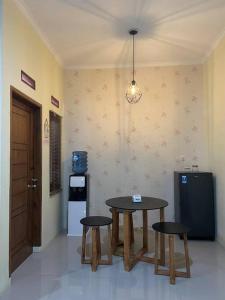 SukarajaSpacious 2BR Home - 14 Min from Sukabumi city Centre by Sakura的厨房配有2张桌子、2把凳子和冰箱。