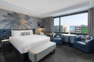 奥克兰Imagine Beach Road的酒店客房设有床、椅子和大窗户。