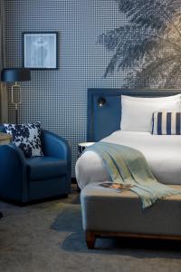 奥克兰Imagine Beach Road的一间卧室配有一张床和一张蓝色椅子