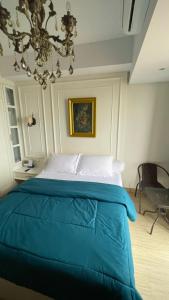巴淡岛中心Alexa Meisterstadt pollux habibie的一间卧室配有一张带吊灯的蓝色床。