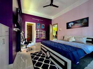 古瓦哈提Three Little Birds Homestay的卧室设有紫色墙壁、一张床和一把椅子