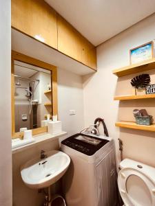马尼拉Condominium at Spring Residences near Airport的一间带水槽、卫生间和镜子的浴室