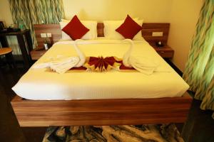 德瓦纳哈利-班加罗尔ZIONS HOTEL AND APERTMENT的酒店客房,配有带毛巾的床