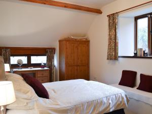 Aber-Brân查尔格罗夫度假屋的一间卧室配有一张床、一张书桌和一个窗户。