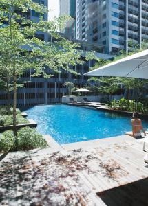 吉隆坡Sfera Residence Kuala Lumpur City Centre的坐在城市游泳池旁的女人