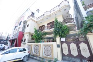 瓦拉纳西Kapoor Sahab Homestay : it's a home away from home.的停在大楼前的白色汽车