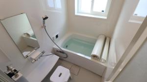 白马村Oak Village的白色的浴室设有浴缸和镜子