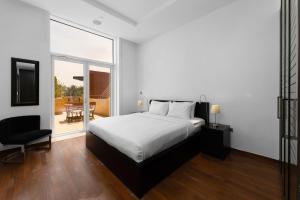 迪拜Maison Privee - Tiara Diamond G06的一间带一张床和一把椅子的卧室以及一个阳台