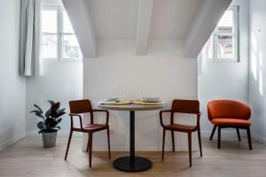 的里雅斯特DOMO Premium Apartments - Trieste Mazzini的一张桌子和三把椅子