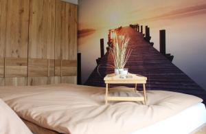昂特保科洛佩因Apartment Blicksüd的一间卧室配有一张床铺,在楼梯旁边配有桌子