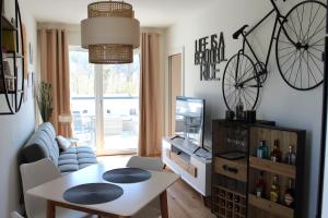 昂特保科洛佩因Apartment Blicksüd的客厅配有桌子和墙上的自行车