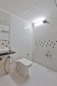 艾哈迈达巴德Hotel Sadbhav的白色的浴室设有卫生间和淋浴。