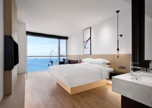 釜山Fairfield by Marriott Busan Songdo Beach的一间卧室配有一张床,享有海景