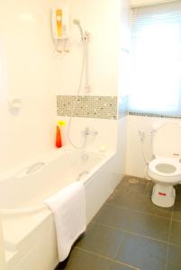 曼谷萨拉达恩假日酒店的白色的浴室设有浴缸和卫生间。