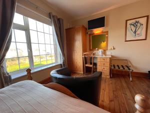 罗斯莱尔St Martin's, Rosslare Harbour Guest Accommodation的一间卧室配有一张床、一张书桌和一个窗户。